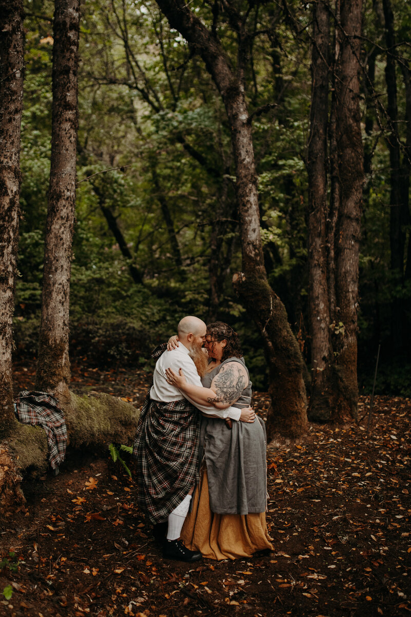 man kisses woman in forest