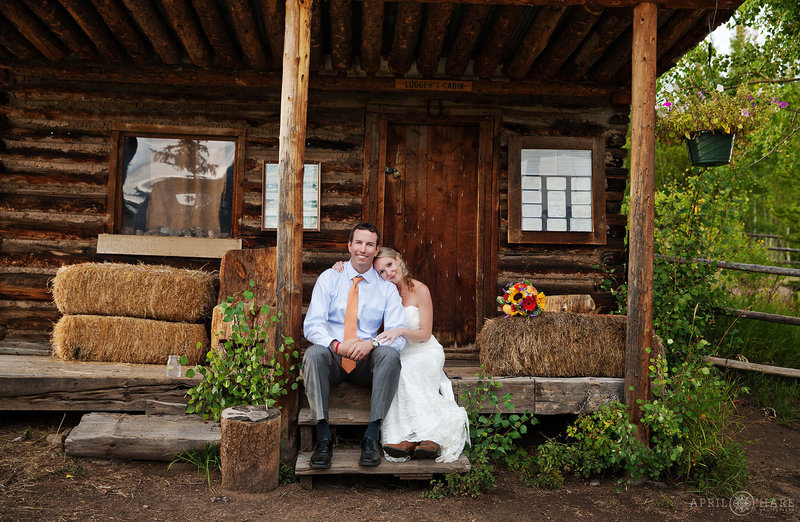 Cute wedding photo on the porch of an old cabin at Rowley Homestead at Snow Mountain Ranch