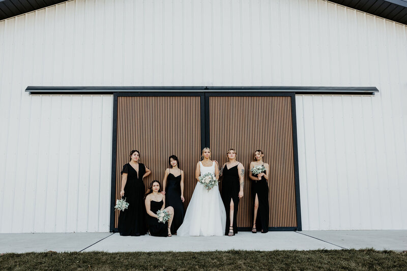 Bride and bridesmaids posing in front of barn doors