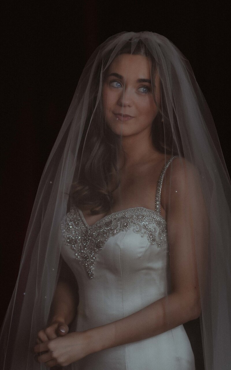 Bride in her veil, capturing a serene and elegant moment of anticipation, embodying timeless beauty and grace as she prepares for her wedding day