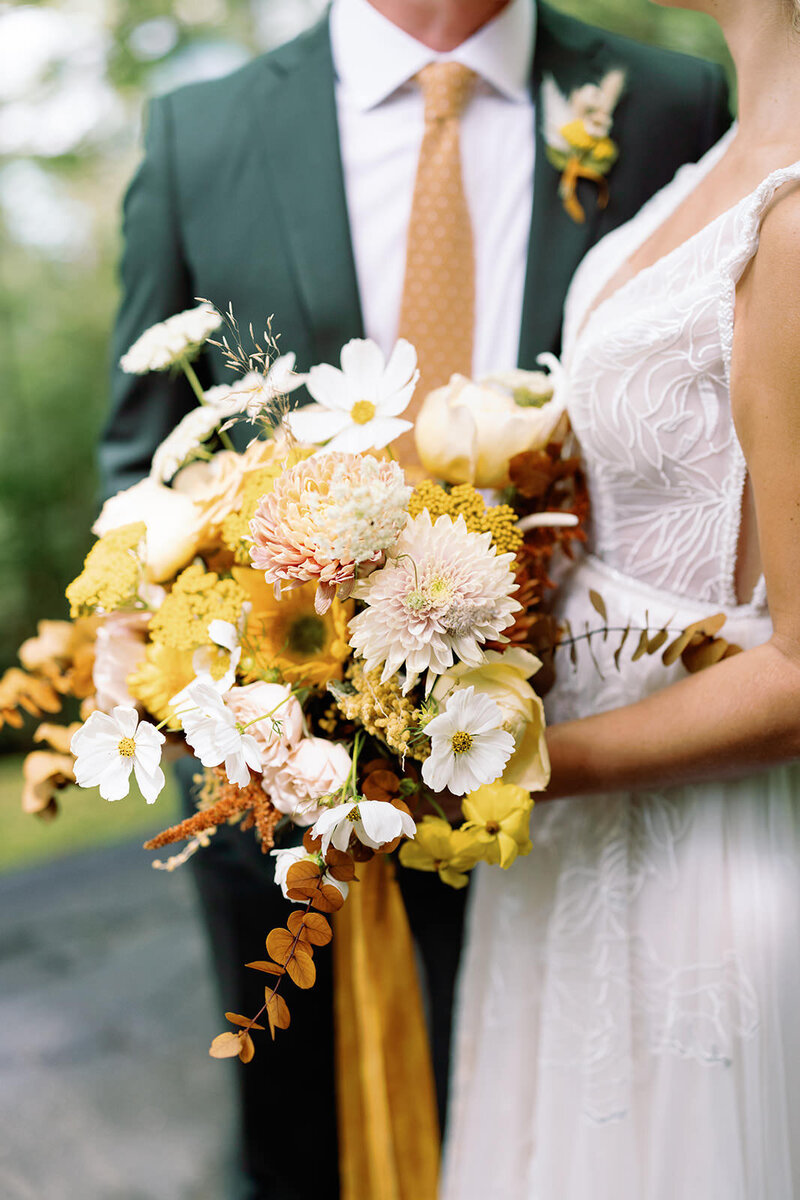Bride and groom hold wedding bouquet