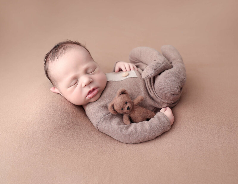 Precious newborn boy posed in our Rochester NY studio.