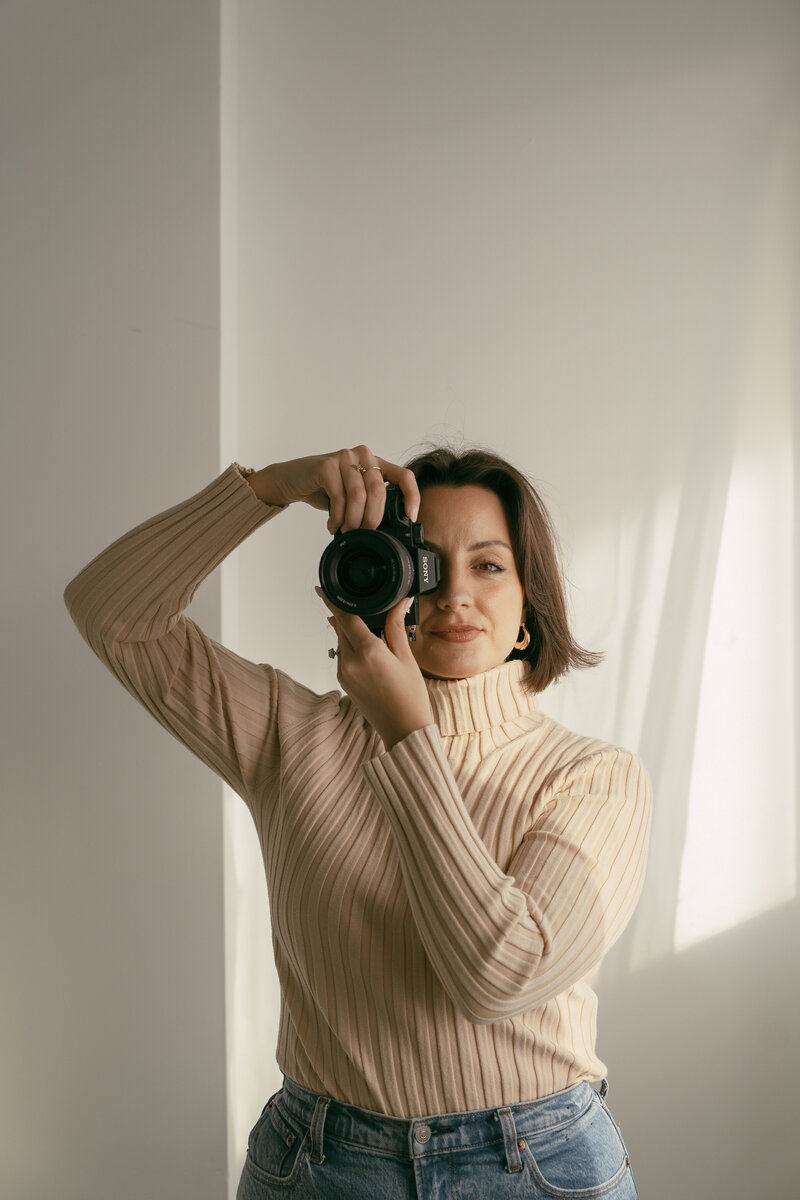 A woman holding a camera up to her face
