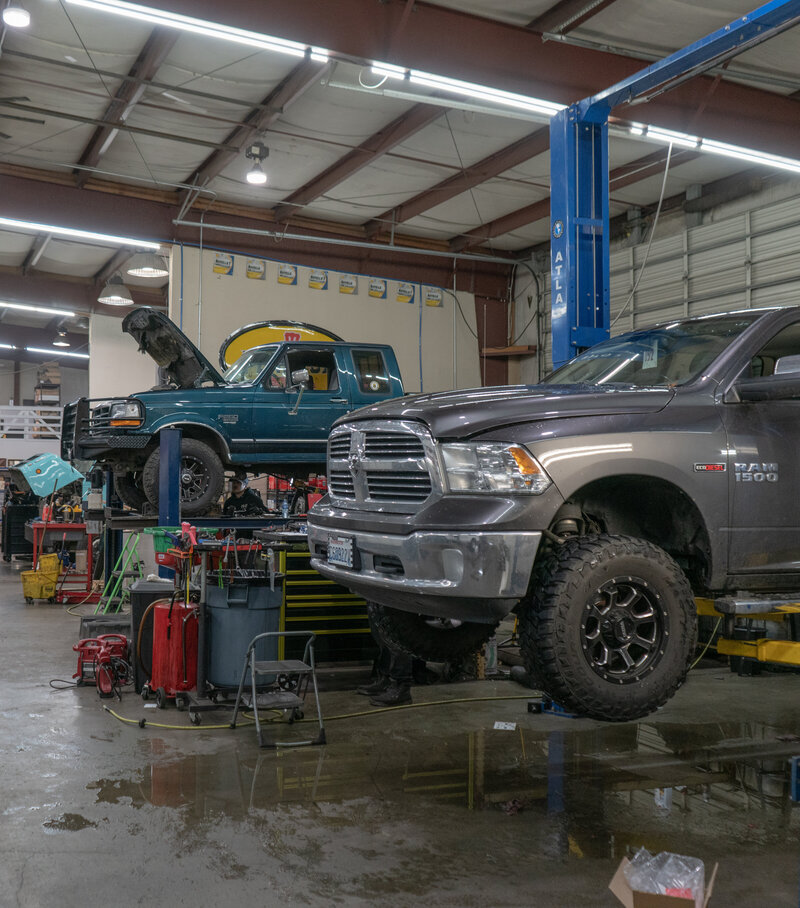 A Ford and Ram being worked on