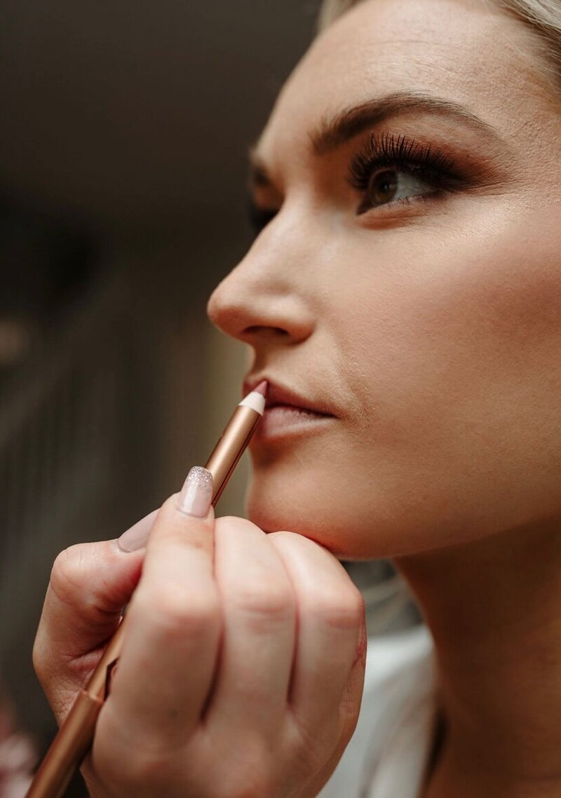 Woman putting on lip liner
