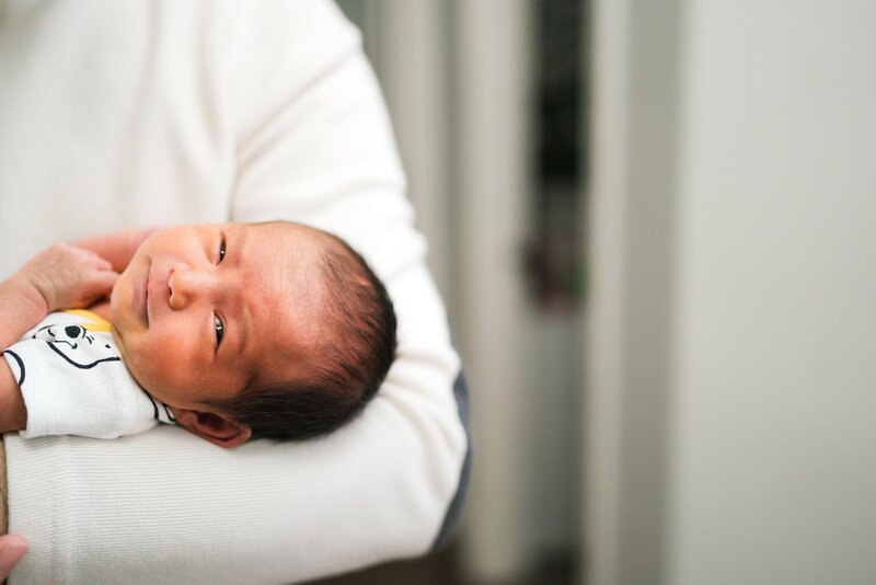 baby in father's arm during Seattle newborn photography session