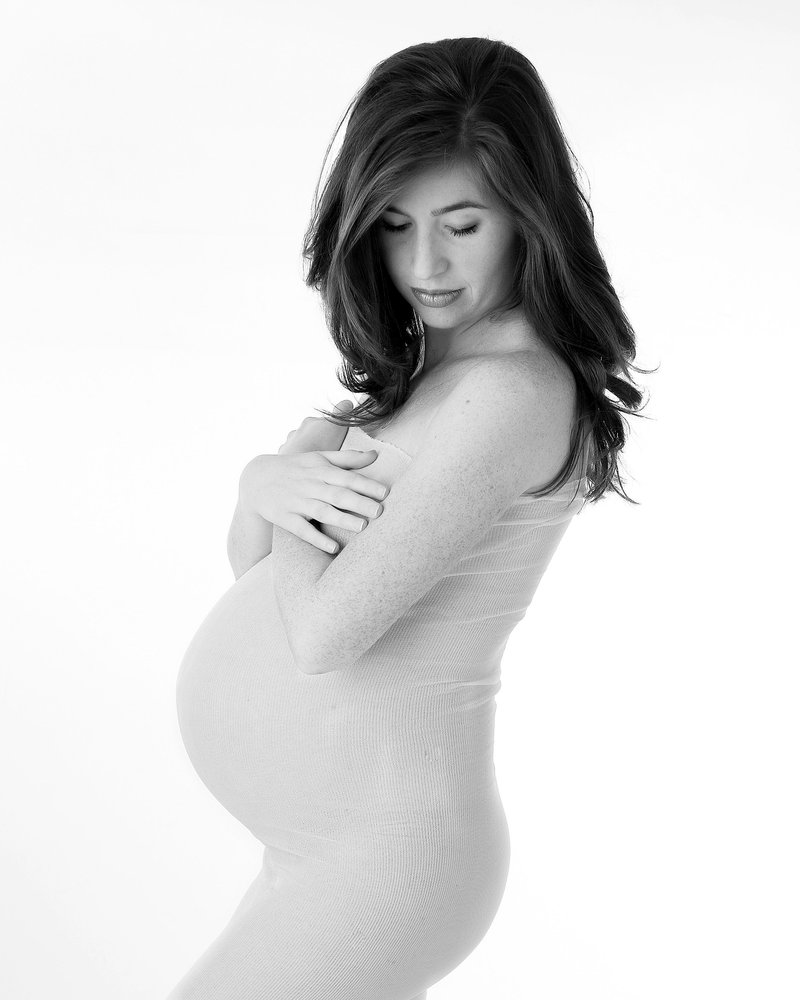 Brunette pregnant woman celebrates her pregnancy in maternity photography session