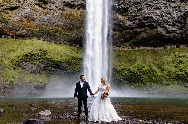 elopement at silver falls state park with couple standing near the waterfall oregon elopement