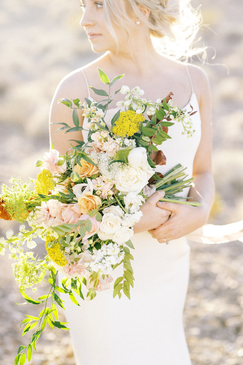 Bride Cradles wedding bouquet in a bright timeless film photo