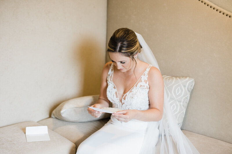 bride reading letter before her woodwinds wedding in Branford CT