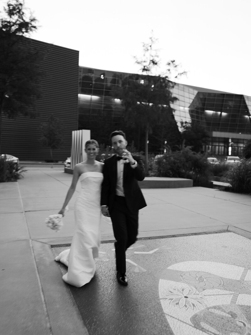 A bride and groom walk to their reception at the Mississippi Museum of Art