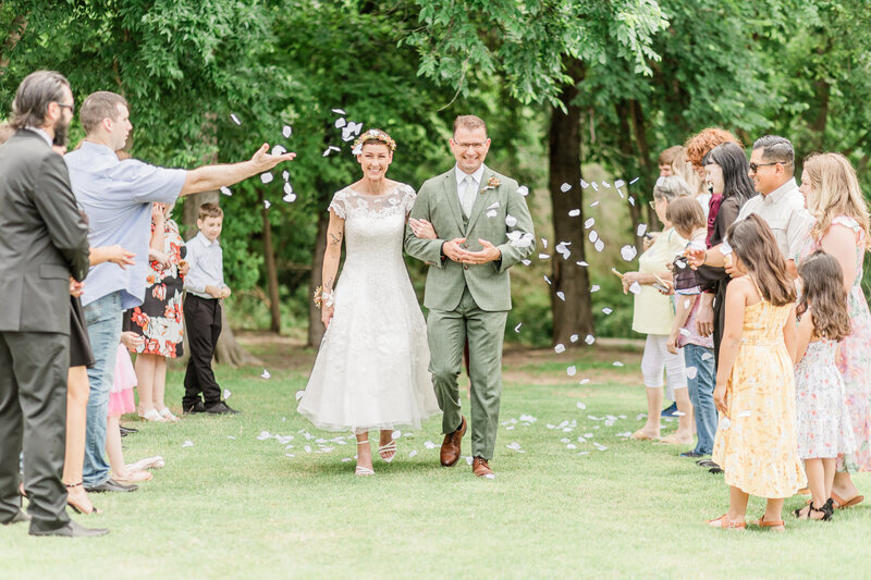 Bride and groom  at petal toss ceremonial exit at their intimate wedding in a park