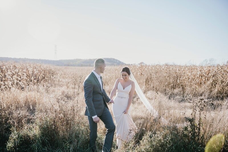 bride and groom walking in corn field