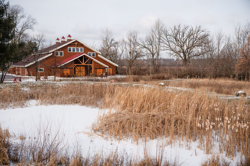 a barn and a field on a snowy winter at barnwood events, a wedding venue in madison, winconsin.
