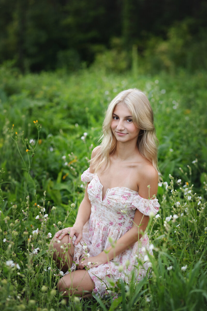 Girl in white dress in field of flowers and green grass
