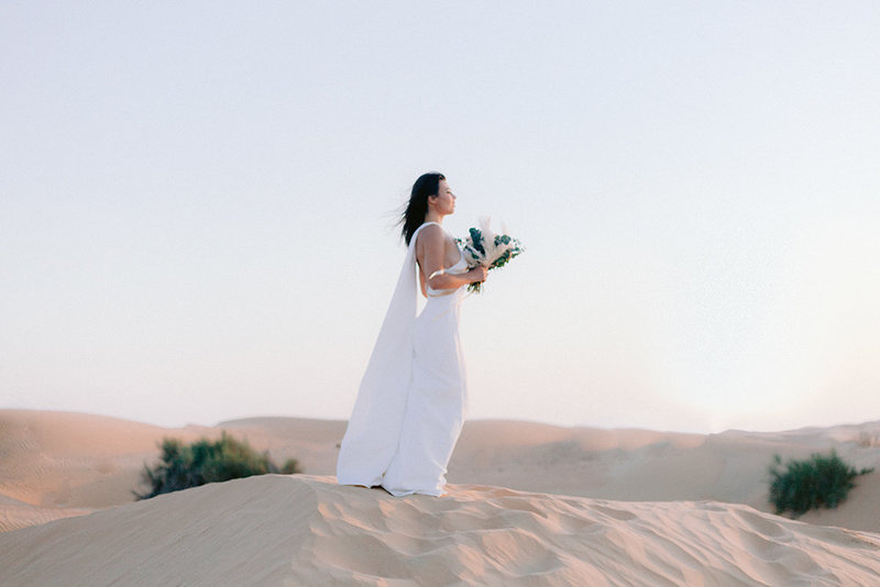 woman on a dune in the desert of Lahbab in Dubai for her wedding wedding photoshoot