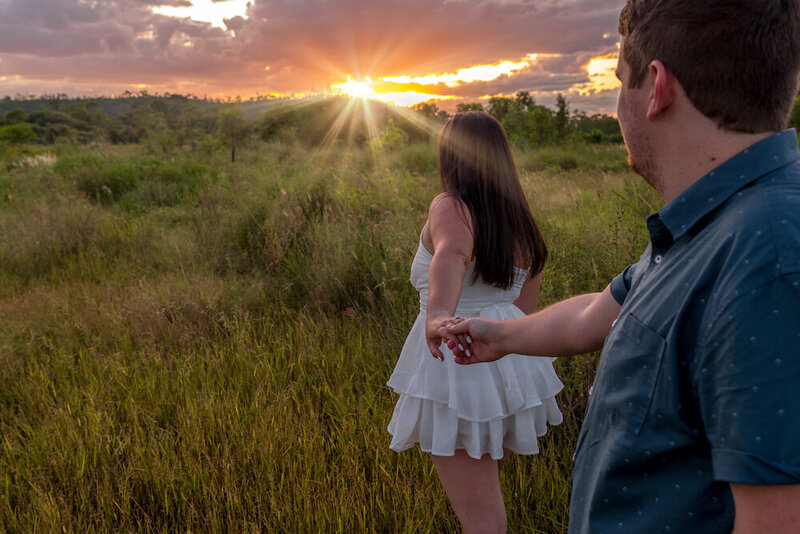 woman in white dress leading fiancé towards the sunset -  townsville engagement photography by Jamie Simmons - Simmons Memorable Moments