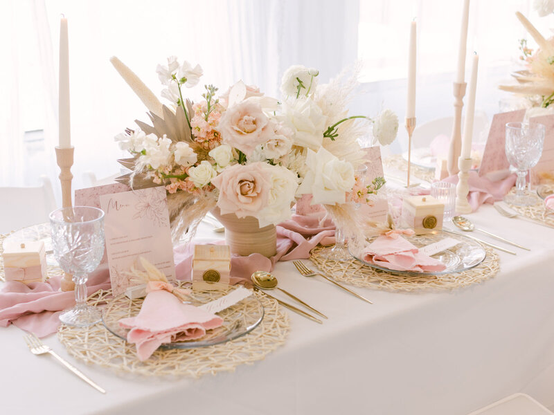 A close-up view of exquisite flowers, elegant candles, and stylish tableware arranged on a table