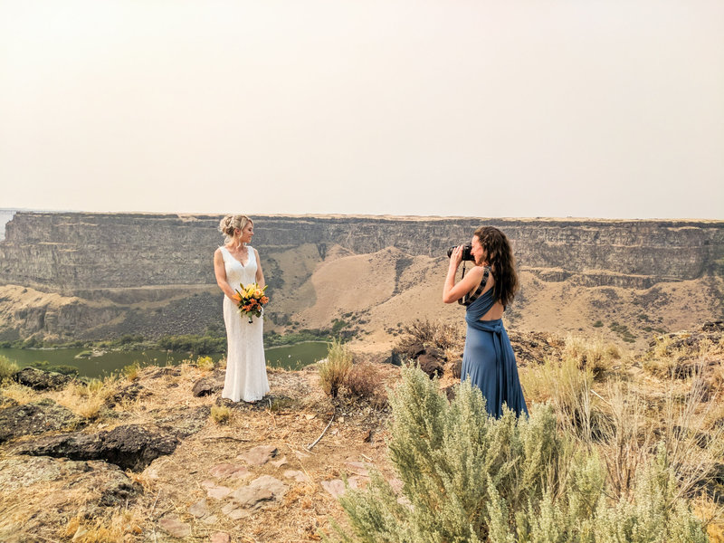 Photographer with bride near a cliff on Snake River Canyon