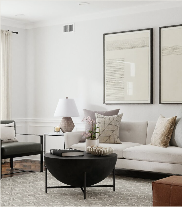 Modern living room with a white sofa, neutral pillows, a black coffee table, and minimalistic wall art, featuring soft lighting and a cozy atmosphere.