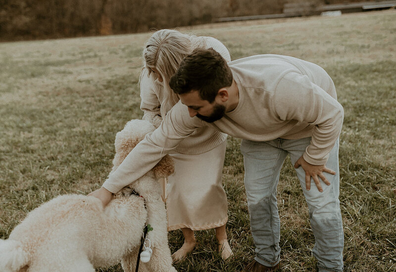 Couple petting Kylee's dog, Ozzy, during their engagement session