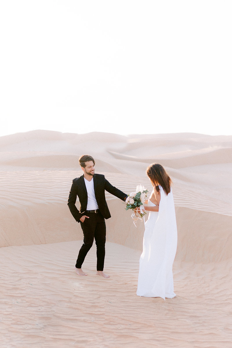 woman and man newly engagement walking in the sand of dubai for a photoshoot in the desert Emira Arab Uni