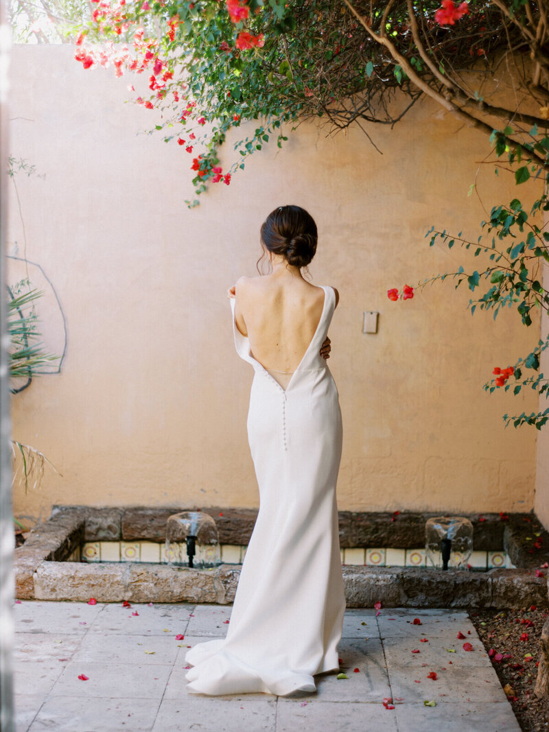 details of bride in low back white wedding gown