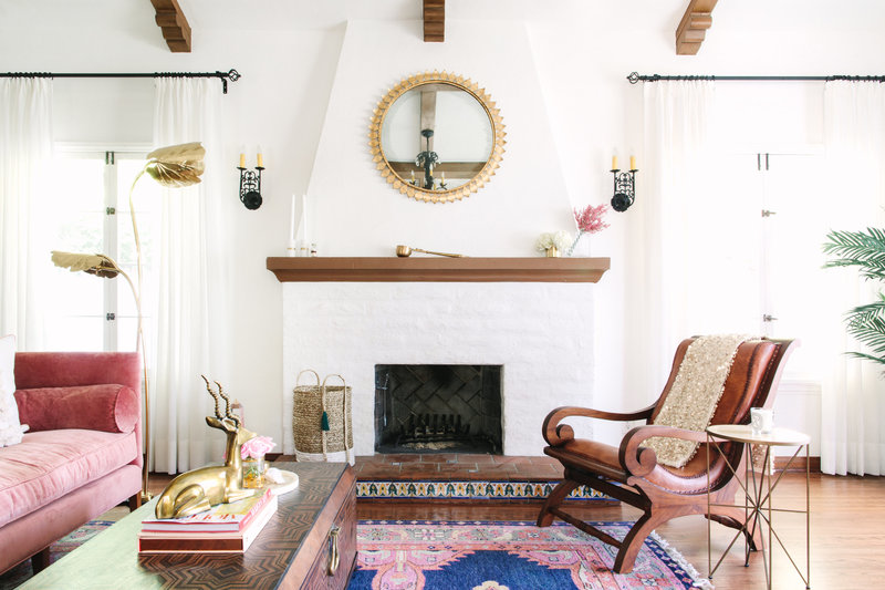 Spanish Colonial Living room with pink velvet sofa, Caitlin Wilson navy Kismet rug, Moroccan coffee table, and leather lounge chair.