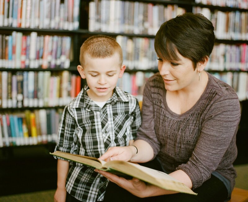 A teacher is reading to a young male student
