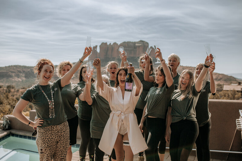 bride and bridesmaids cheering champagne at cathedral  rock in sedona