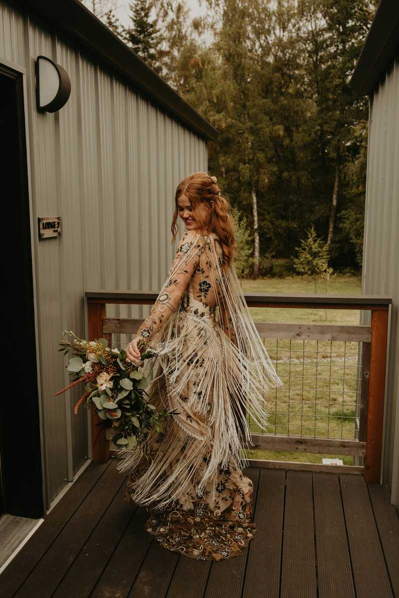 Bohemian bride spins in circle smiling in her wedding dress