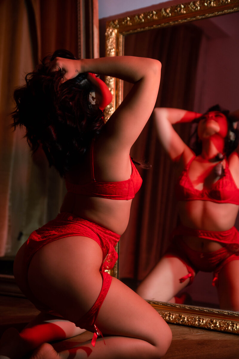 woman in red lingerie posing in front of a mirror