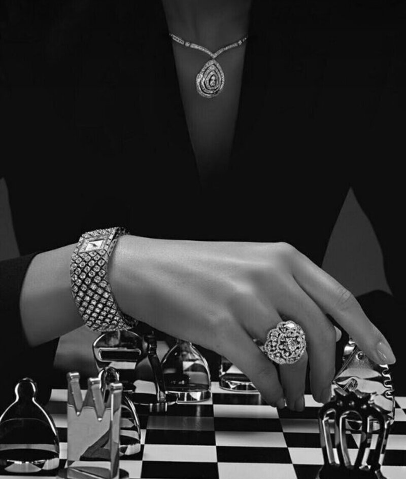 woman's hand with rings playing chess