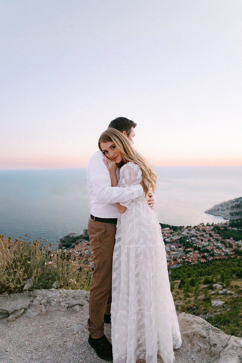couple hugging after eloping in dubrovnik on top of srd hill at sunset