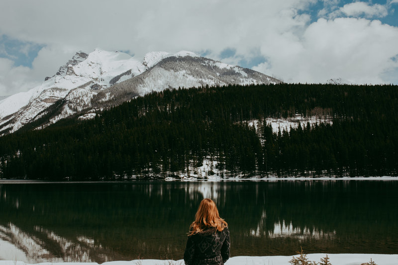 woman looking out over lake and mountains
