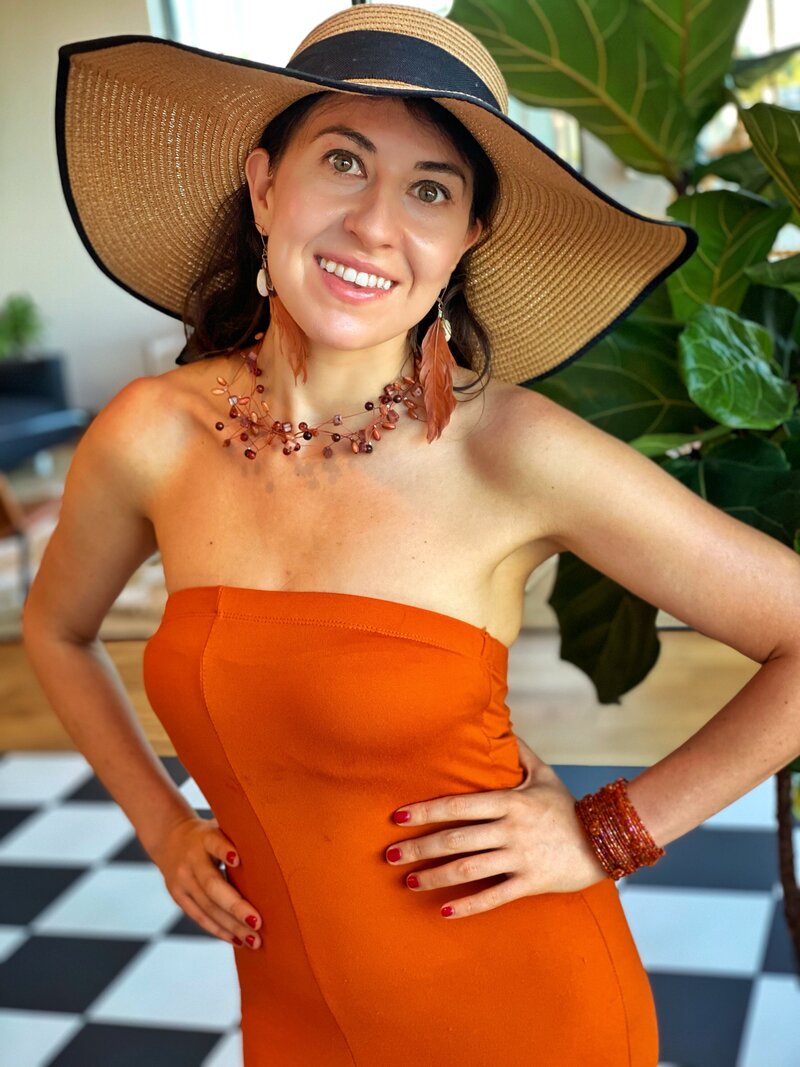 Ana-Maria Georgieva in an orange dress and a sun hat