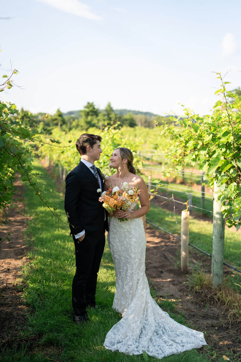 bride and groom smiling at each other in an orchard by atlanta wedding photographers