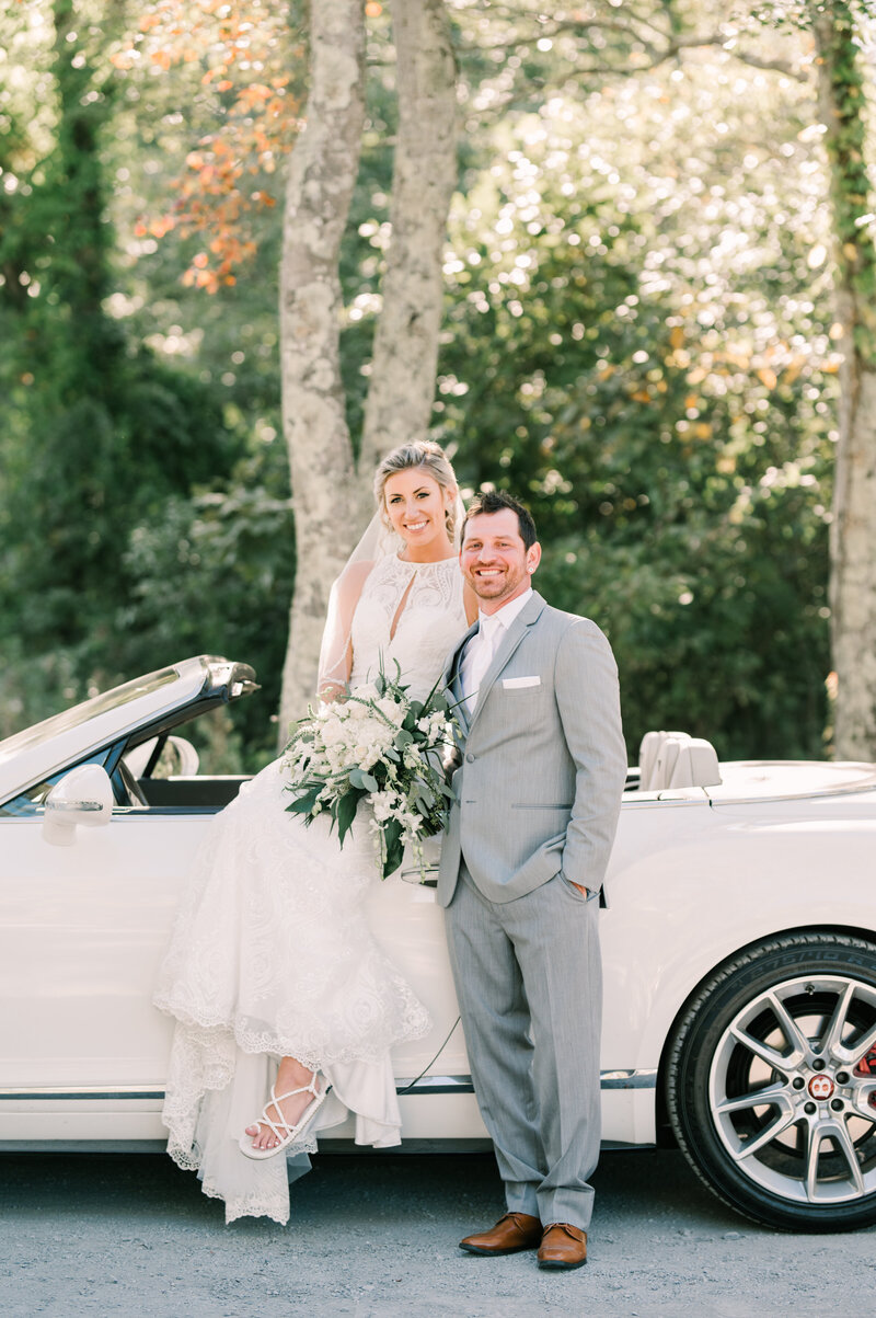 Couple poses on next to convertible