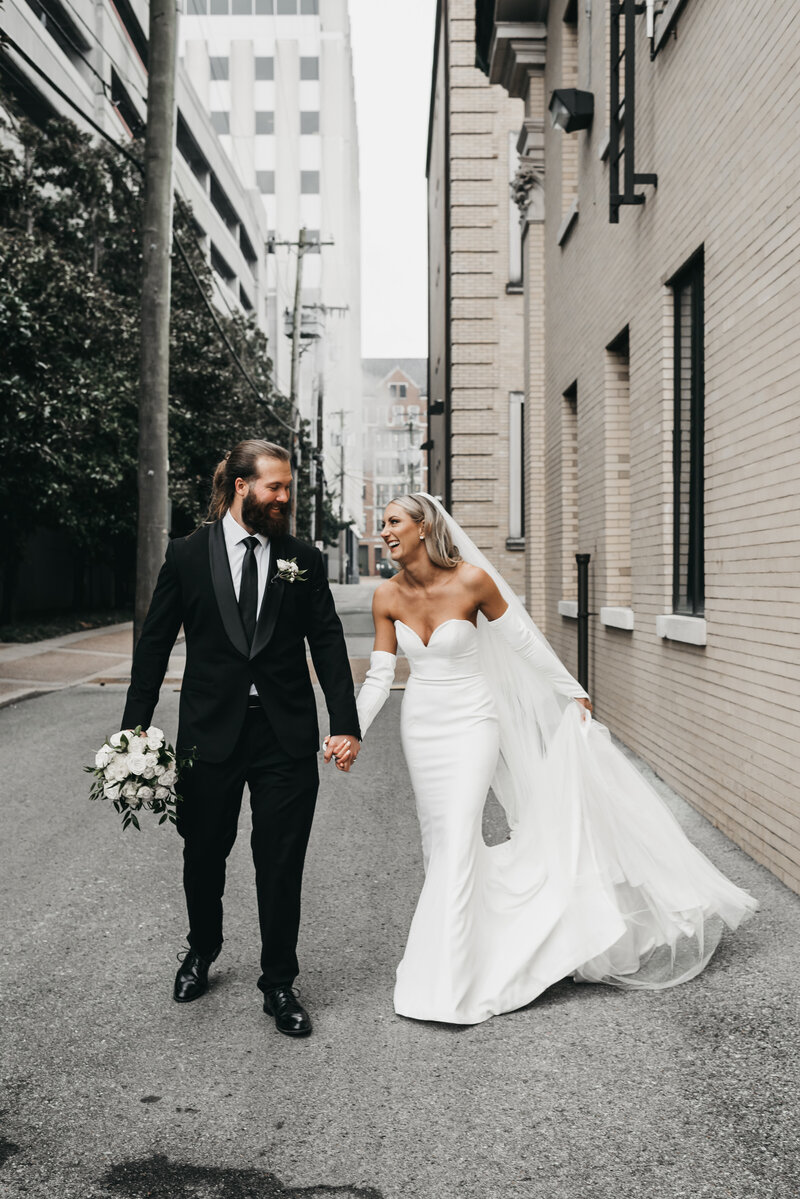 Newlywed couple holding hands in Nashville city road