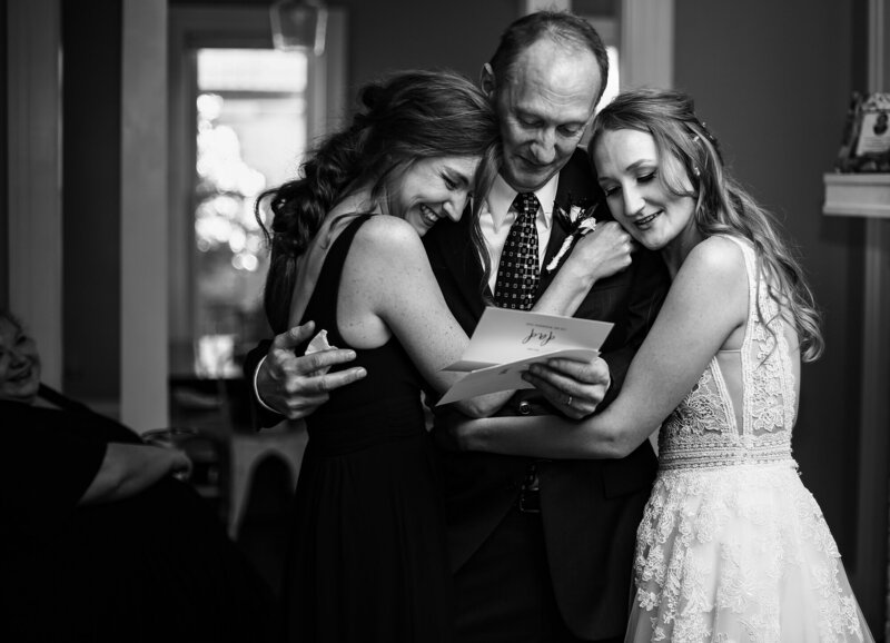 Bride hugging her sister and father before the ceremony