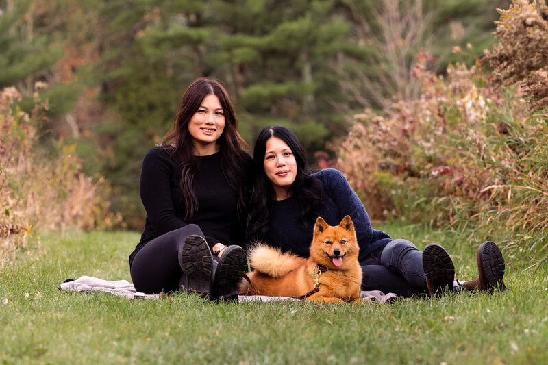 Two women snuggle with their dog and each other by  Vermont Family Photographer