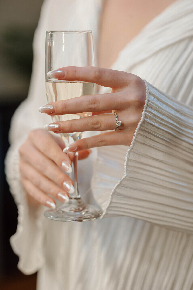 Bride holds champagne glass