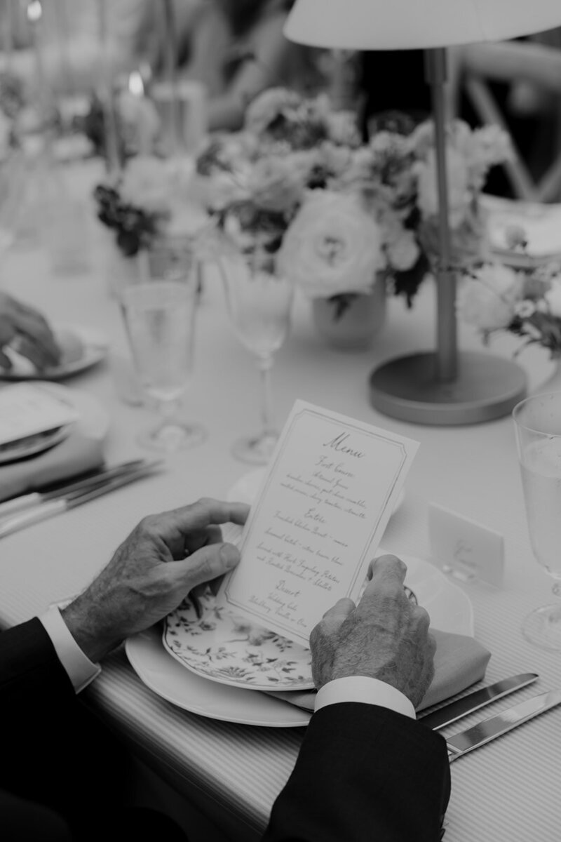 Wedding guest reading the menu for the wedding reception