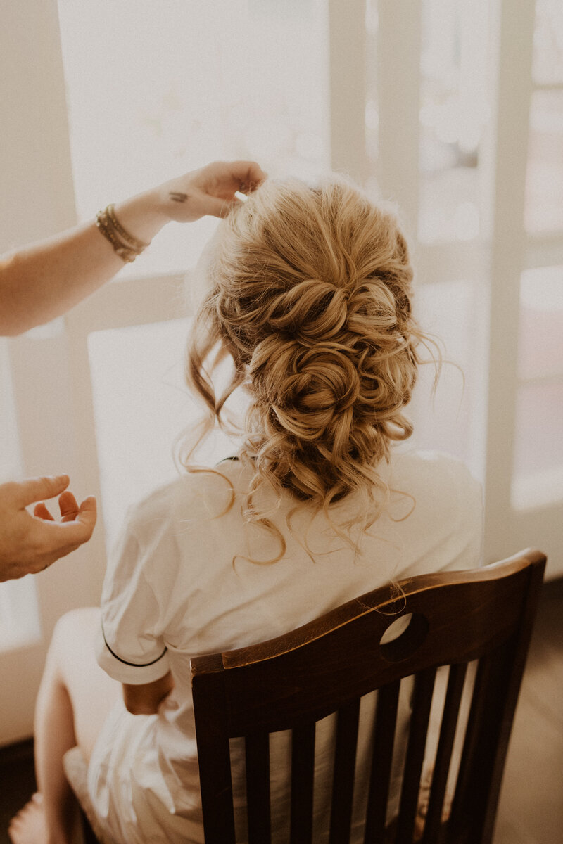 woman styling bride's hair