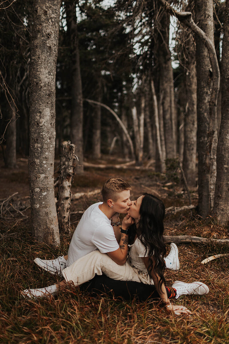 couple kissing on forest floor