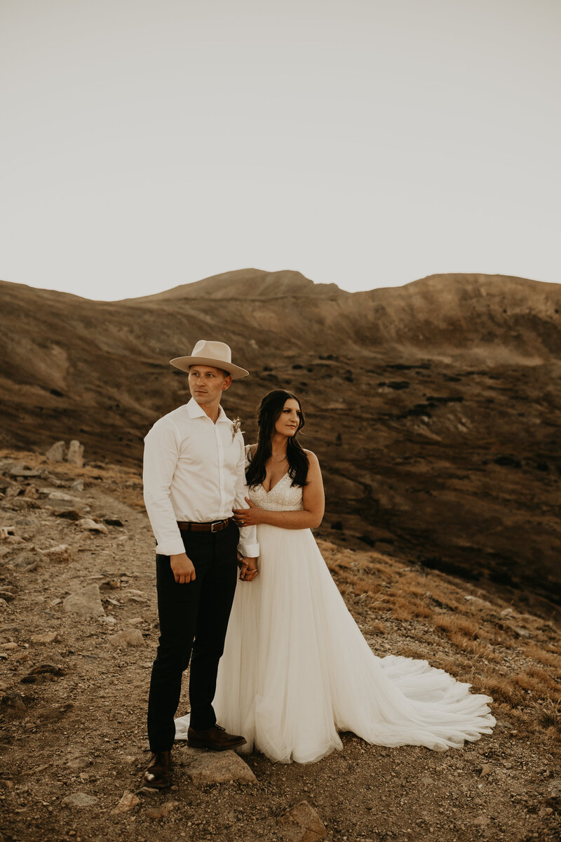 bride and groom posing on mountaintop