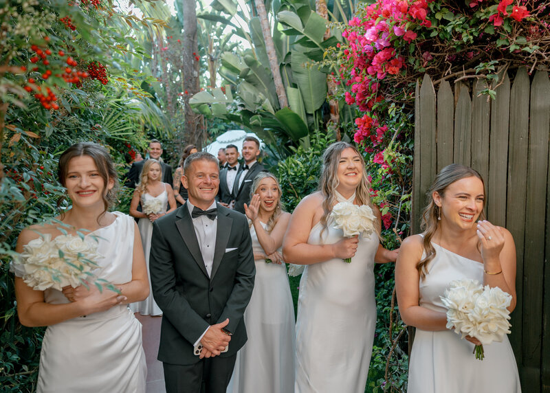 An intimate moments as the brides dad and bridesmaids get a glimpse of the bride as she makes her way to the ceremony of this famous Beverly Hills Hotel wedding in California.