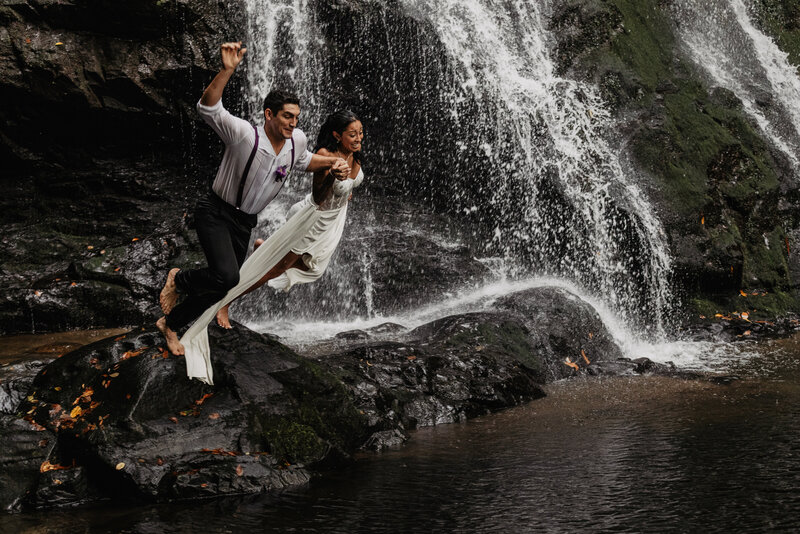 Wedding couple jumping in waterfall at Spruce Flats Falls in the Smoky Mountains