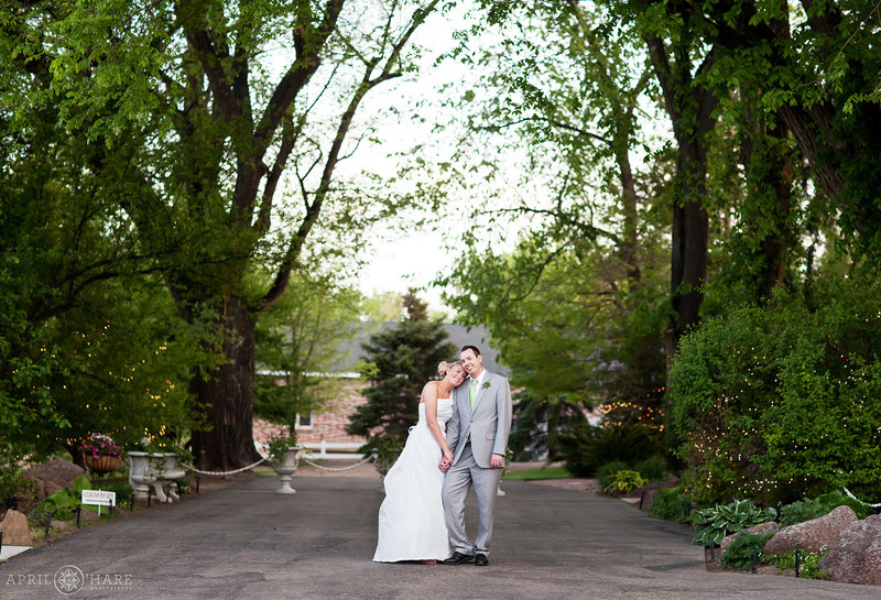 Bride and Groom pose on tree lined driveway at Tapestry House in Laporte Colorado