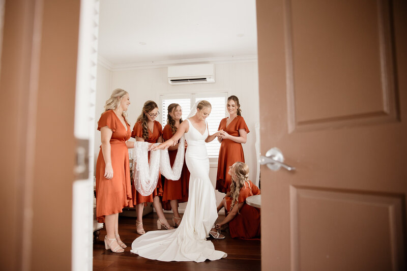Dressing bride in doorway with the bridesmaids